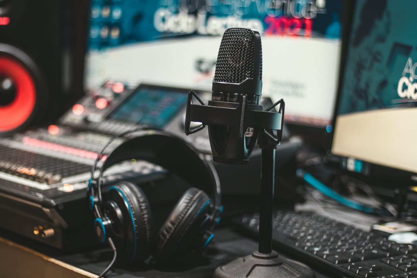 Condenser microphone and audio equipment in a studio setting.