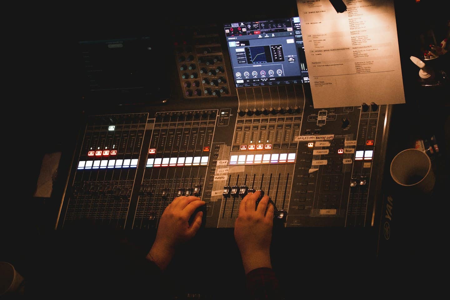 Sound engineer mixing audio on a large digital console.