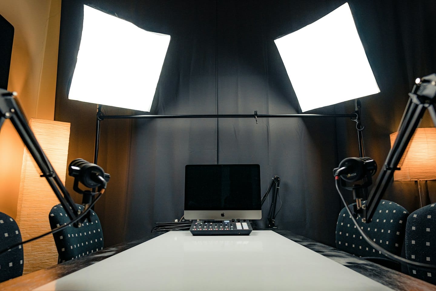 Empty podcast studio with microphones and mixing equipment.